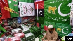 A shopkeeper arranges flags of political parties at his shop ahead of the upcoming general elections in Karachi, Pakistan, on Jan. 3, 2024. 