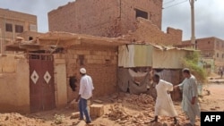 FILE: People check a damaged house in southern Khartoum on June 12, 2023 as deadly shelling and gunfire resumed after the end of a 24-hour ceasefire in Sudan.