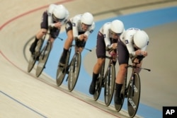 The United States' Jennifer Valente, Lilly Williams, Chloe Dygert and Kristen Faulkner compete on their way to clinch the gold medal in the women's team pursuit event, at the Summer Olympics, Aug. 7, 2024, in Paris.