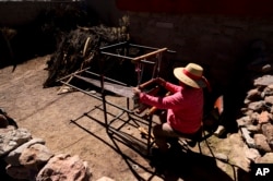 Teofila Challapa weaves on her loom at home in Cariquima, Chile, on July 31, 2023. Challapa prays before beginning her work: “Mother Earth, give me strength, because you're the one who will produce, not me."
