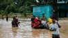 FILE - People move a cart with a woman and a child through a flooded street, amid severe flooding in the Fazilpur area of Feni, Bangladesh, Aug. 26, 2024. 