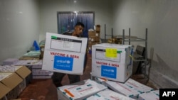 Seorang pekerja membongkar kiriman vaksin polio yang dikirim ke Jalur Gaza melalui penyeberangan Karm Abu Salem, juga dikenal sebagai Kerem Shalom, di depo milik Kementerian Kesehatan Gaza, 25 Agustus 2024. (Foto: Eyad Baba/AFP)