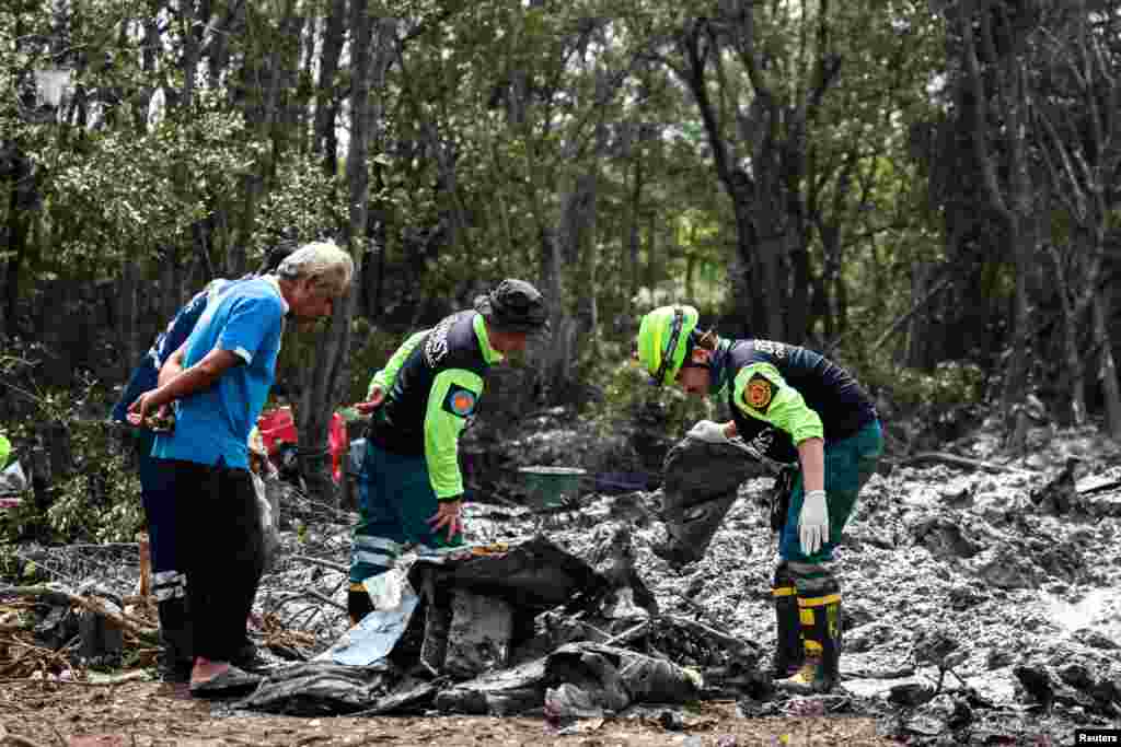 Rescue workers search the wreckage of a small aircraft a day after it crashed, with five tourists from China and four Thais, including the two pilots, all presumed dead, in Bang Pakong, Chachoengsao province, Thailand.