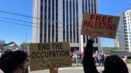 Para pengunjuk rasa pro-Palestina meneriakkan slogan-slogan di luar Konsulat Israel di Atlanta, 8 Oktober 2023. Seorang pengunjuk rasa yang membawa bendera Palestina membakar diri luar gedung itu pada Jumat, 1 Desember 2023. (Foto: Jeff Amy/AP Photo)