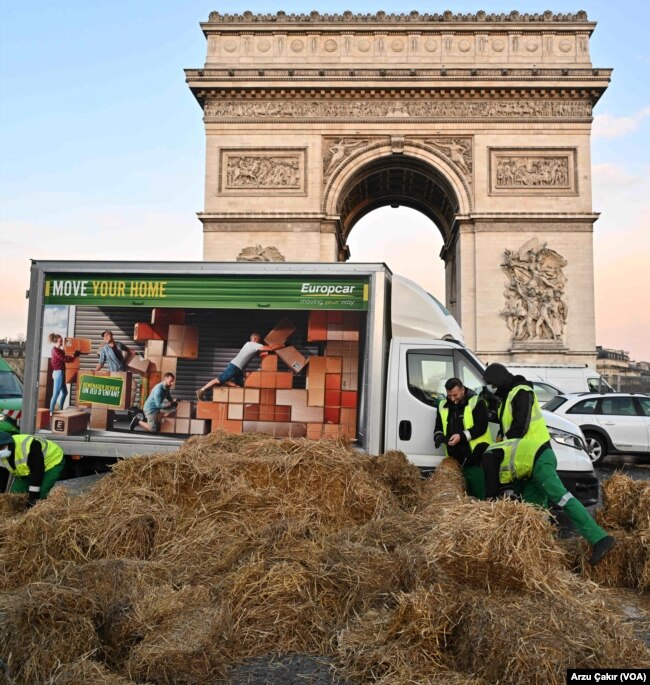 Yaklaşık 150 çiftçi, Champs-Elysees Caddesi’nin başındaki sembolik Zafer Takı’nı saman balyaları ve traktörleriyle çevreleyerek eylem yaptı.