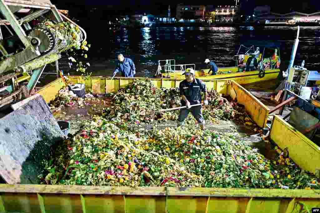 Trabalhadores municipais recolhem &quot;Krathong&quot; ou cestos flutuantes lançados no rio Chao Phraya para assinalar as celebrações anuais do festival Loy Krathong, durante uma ação de limpeza em Banguecoque, Tailândia, 27 de novembro de 2023.