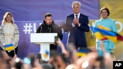 Ukraine's President Volodymyr Zelenskyy, second left, and Lithuania's President Gitanas Nauseda, second right, address the public from a stage during an event on the sidelines of a NATO summit in Vilnius, Lithuania, July 11, 2023.