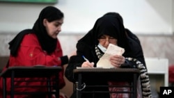 Voters fill out their ballots during the parliamentary and Assembly of Experts elections at a polling station in Tehran, Iran, March 1, 2024.