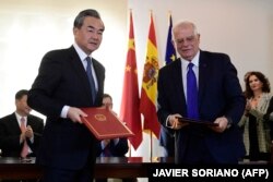 Menteri Luar Negeri China Wang Yi (kiri) bertukar dokumen dengan sejawatnya dari Spanyol Josep Borrell selama penandatanganan perjanjian antara kedua negara di Istana Moncloa di Madrid pada 28 November 2018. (Foto: AFP/JAVIER SORIANO)