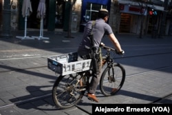 David, reservista llamado a filas desde que comenzó la guerra contra Hamás, pasea en bicicleta por una céntrica calle de Jerusalén.