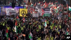 Manifestantes portan carteles y banderas palestinas en una marcha en Londres el 25 de noviembre de 2023.