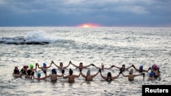 FILE - A group consisting mostly of women, who call themselves "The Endorphins", gather for a sunrise swim in the chilly waters of Lake Ontario during freezing temperatures in Toronto, Ontario, Canada, Jan. 17, 2024. (REUTERS/Carlos Osorio)