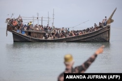 Pengungsi Rohingya yang baru tiba terdampar di perahu karena masyarakat sekitar memutuskan untuk tidak mengizinkan mereka mendarat setelah memberikan air dan makanan di Pineung, Aceh, 16 November 2023. (Foto: AMANDA JUFRIAN/AFP)