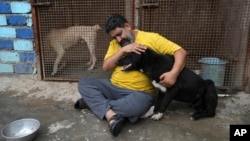 Iranian cleric Sayed Mahdi Tabatabaei caresses an impaired stray dog at his shelter outside the city of Qom, Iran, May 21, 2023.