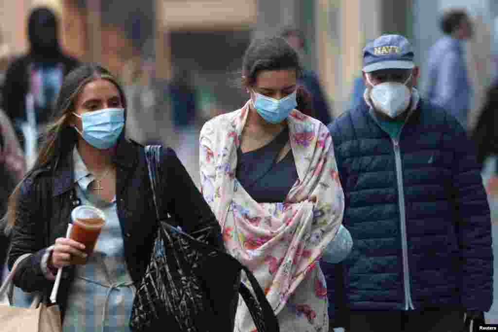 People wear protective face masks as they walk in midtown Manhattan as haze and smoke caused by wildfires in Canada continue to linger over New York City, June 8, 2023.