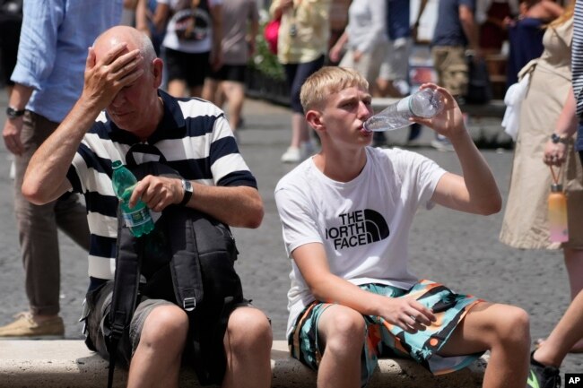 Turis-turis sedang minum di tengah gelombang panas di Roma, Italia, dengan suhu mencapai 40 derajat Celsius di banyak kota di Italia, Sabtu, 8 Juli 2023. (Foto: Gregorio Borgia/AP Photo)