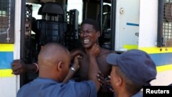 FILE —Police officials detain a protester from Sir Lowry's Pass Village during a protest over water supply in the area in Cape Town, South Africa.