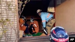 In this image from a video provided by the Osaka Municipal Fire Department, rescuers work to free a woman trapped under her destroyed house for 72 hours after an earthquake in Wajima, Ishikawa prefecture, Japan, Jan. 4, 2024. (Osaka Municipal Fire Department via AP).