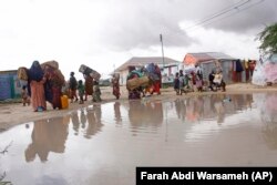 Pengungsi Somalia mengosongkan penampungan sementara mereka yang diterjang banjir besar di Mogadishu, Somalia, Senin, 13 November 2023. (AP/Farah Abdi Warsameh)