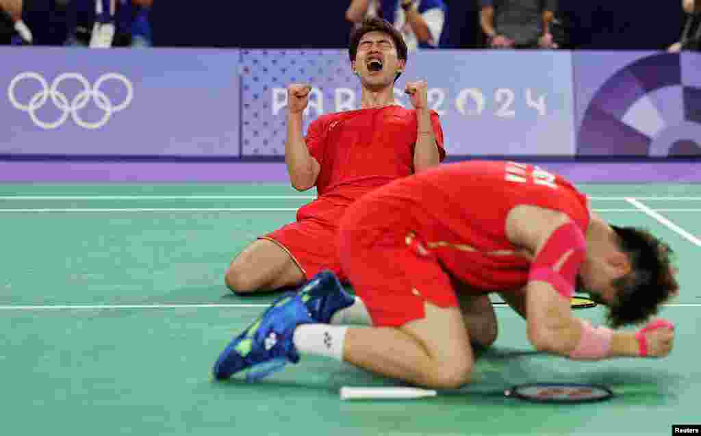 Wei Keng Liang and Chang Wang of China celebrate after winning the match against Fajar Alfian and Muhammad Rian Ardianto of Indonesia during the men&#39;s doubles badminton quarterfinals at the Porte de la Chapelle Areana in Paris, France.