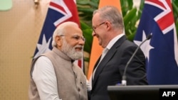 Perdana Menteri Australia Anthony Albanese (kanan) berjabat tangan dengan Perdana Menteri India Narendra Modi saat mereka mengakhiri konferensi pers bersama mereka di Admiralty House, Sydney, 24 Mei 2023. (Saeed KHAN / POOL / AFP)