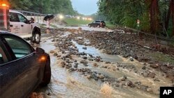 Vehicles come to a standstill near a washed-out and flooded portion of the Palisades Parkway just beyond the traffic circle off the Bear Mountain Bridge, July 9, 2023, in Orange County, New York.