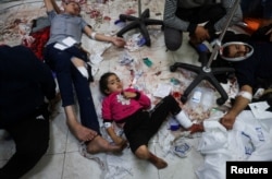 FILE - Wounded Palestinians lie on the floor at Nasser hospital, following Israeli strikes on Ma'an school east of Khan Younis, in the southern Gaza Strip, Dec. 5, 2023.