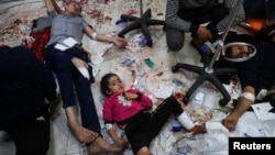 FILE - Wounded Palestinians lie on the floor at Nasser hospital, following Israeli strikes on Ma'an school east of Khan Younis, in the southern Gaza Strip, Dec. 5, 2023.