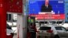 Sebuah layar menampilkan siaran pidato kenegaraan tahunan Presiden Rusia Vladimir Putin, saat seorang karyawan mengisi BBM di sebuah pompa bensin di Moskow, 29 Februari 2024. (Olga MALTSEVA / AFP )