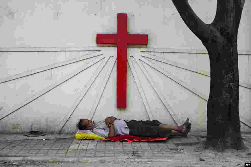 A man sleeps at a pavement outside a church in Secunderabad, the twin city of Hyderabad.