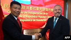 Honduran Foreign Minister Eduardo Enrique Reina, right, and Chinese envoy Yu Bo shake hands during the inauguration of the Chinese embassy in Tegucigalpa on June 5, 2023.
