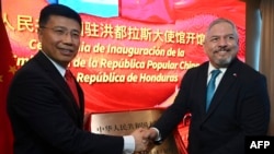 Menteri Luar Negeri Honduras Eduardo Enrique Reina (kanan) dan utusan pemerintah China Yu Bo saling berjabat tangan dalam acara peresmian Kedutaan Besar China di Tegucigalpa, Honduras, pada 5 Juni 2023. (Foto: AFP/Orlando Sierra)