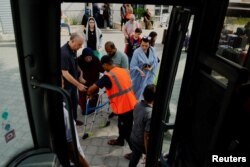 Suzan Besaiso, Palestinka sa pasošem SAD, sa majkom ulazi u autobus koji treba da ih odveze preko graničnog prelaza Rafa iz Gaze u Egipat, 2. novembra 2023.