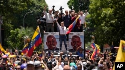 Opposition leader Maria Corina Machado holds a national flag while waving to supporters as she arrives for a rally in Caracas, Venezuela, Aug. 3, 2024.