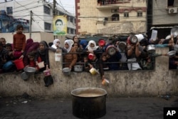 FILE - Palestinians line up for a free meal in Rafah, Gaza Strip, Dec. 21, 2023.
