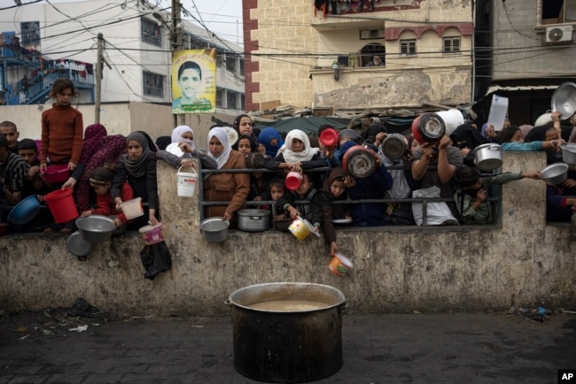 FILE - Palestinians line up for a free meal in Rafah, Gaza Strip, Dec. 21, 2023.