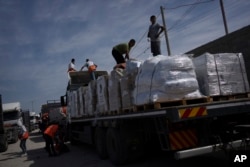Trucks with humanitarian aid for the Gaza Strip enter from Egypt in Rafah on Oct. 21, 2023.