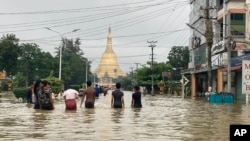 Local residents wade through a flooded road near Shwe Maw Taw pagoda in Bago, about 80 kilometers (50 miles) northeast of Yangon, Myanmar, Oct. 9, 2023. 