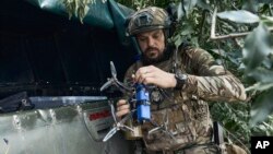 Un soldado ucraniano prepara un dron en la línea del frente en la región de Zaporizhzhia, Ucrania, el sábado 1 de julio de 2023. (AP Photo/Libkos)