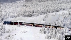 Kereta uap melintasi lanskap yang tertutup salju dalam perjalanan menuju gunung tertinggi 'Brocken' setinggi 1.142 meter (3.743 kaki) di Jerman utara di pegunungan Harz dekat Schierke, Jerman, Rabu, 17 Januari 2024. (AP Photo/Matthias Schrader )