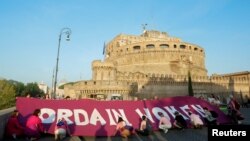 People hold a banner as they protest for the ordination of women to priestly office ahead of the opening of the Synod of Bishops near the Vatican, in Rome, Oct. 4, 2023.
