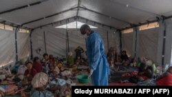 Dr. Robert Musole, medical director of the hospital in Kavumu, South Kivu Province, Democratic Republic of the Congo, visits patients recovering from smallpox.