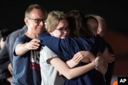 Alsu Kurmasheva, segunda desde la derecha, abraza a su esposo Pavel Butorin, desde la izquierda, y a sus hijas Miriam Butorin y Bibi Butorin en la Base de la Fuerza Aérea Andrews, Maryland, luego de su liberación de Rusia el 1 de agosto de 2024.