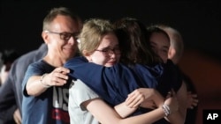 Alsu Kurmasheva, second right, hugs husband Pavel Butorin, from left, and daughters Miriam Butorin and Bibi Butorin at Andrews Air Force Base, Md., following her release from Russia Aug. 1, 2024.