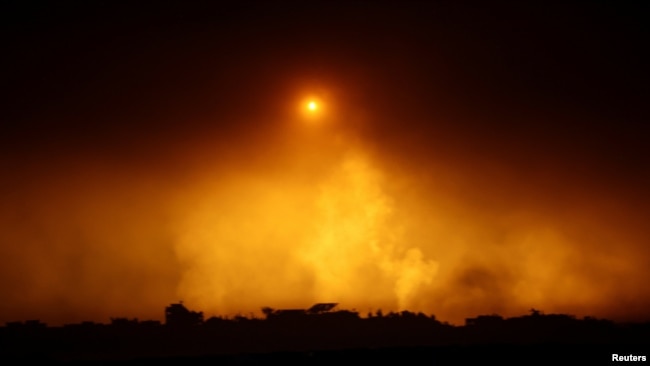 A flare falls over Gaza during the ongoing conflict between Israel and Hamas, as seen from southern Israel, Dec. 7, 2023.