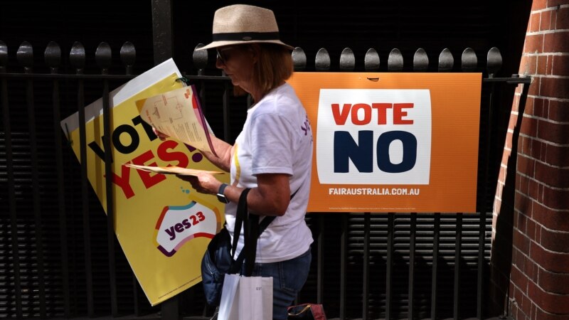 Seorang sukarelawan membagikan brosur pemungutan suara di luar tempat pemungutan suara di pusat kota Sydney, 3 Oktober 2023. (DAVID GREY / AFP)