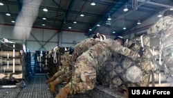 FILE - U.S. Air Force Airmen load pallets of ammunition to be transferred to a C-130 Hercules on Ramstein Air Base, Germany, Aug. 7, 2022.