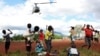 FILE - Children in Mulanje look on as a military helicopter carry doctors and medical supplies to Muloza on the border with Mozambique which are cut off after the tropical Cyclone Freddy outside Blantyre, Malawi, March 18, 2023.
