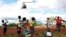FILE - Children in Mulanje look on as a military helicopter carry doctors and medical supplies to Muloza on the border with Mozambique which are cut off after the tropical Cyclone Freddy outside Blantyre, Malawi, March 18, 2023.