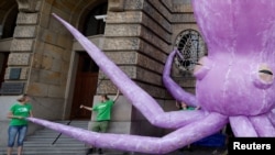 FILE - Greenpeace activists stand in front of the Ministry of Industry to stage a protest demanding an end to deep sea mining, Prague, Czech Republic, June 1, 2023. Negotiations about the future of deep sea mining and mineral extraction kicked off Monday in Jamaica,